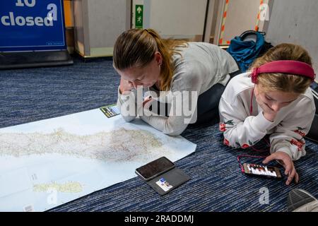 Una famiglia trascorre il tempo sul pavimento in un corridoio su un carico di traghetti da Wellington a Picton, attraversando da North Island a South Island, nuova Zelanda Foto Stock