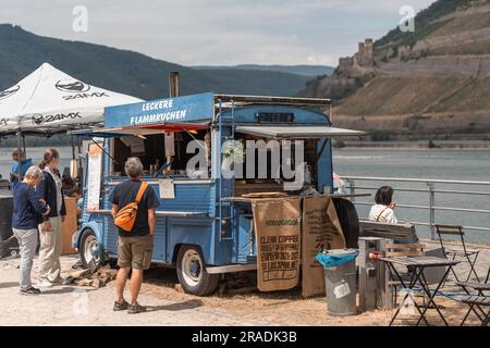 Bingen am Rhein, Germania. 2 luglio 2023. Camion di catering Street food d'epoca di fronte al pittoresco paesaggio del fiume Reno. Una volta all'anno, la passeggiata sulla costa della cultura del Reno (Kulturufer) si trasforma in un palcoscenico lungo tre chilometri con cibo e vari atti che presentano arte, commedia e cabaret. Credito: Gustav Zygmund/Alamy News Foto Stock