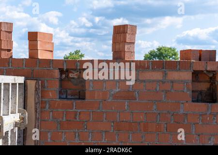 Muro di mattoni incompiuto della casa. Muratura. Costruzione di un muro di mattoni. Mattoni di argilla pieni utilizzati per la costruzione. Concetto di riparazione e costruzione m Foto Stock