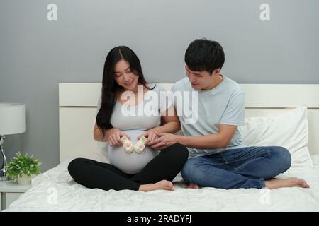 marito e sua moglie incinta con calzino o scarpa sulla pancia Foto Stock