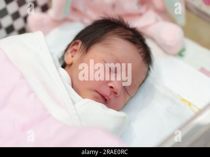 neonato che deposizione e dorme nel cestino di culla infantile in ospedale Foto Stock