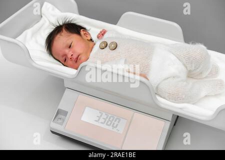 misurazione del peso del neonato sulle bilance digitali Foto Stock