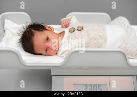 misurazione del peso del neonato sulle bilance digitali Foto Stock