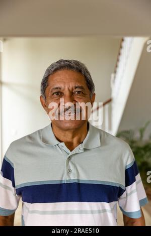 Ritratto di un uomo birazziale anziano felice a casa Foto Stock