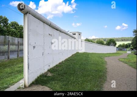 17 giugno 2023, Thürigen, Mödlareuth: Una parte del muro di barriera in cemento conservato originale all'ex confine interno-tedesco vicino a Mödlareuth. A causa della sua somiglianza con il muro di Berlino, la sezione di confine divenne nota anche come "piccola Berlino". Oggi, il memoriale del Museo tedesco-tedesco si trova qui. Foto: Heiko Rebsch/dpa Foto Stock