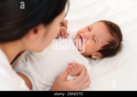 madre con bambino appena nato che piange su un letto Foto Stock