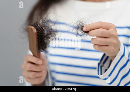 donna da vicino che ha problemi di perdita dei capelli con la sua spazzola per capelli Foto Stock