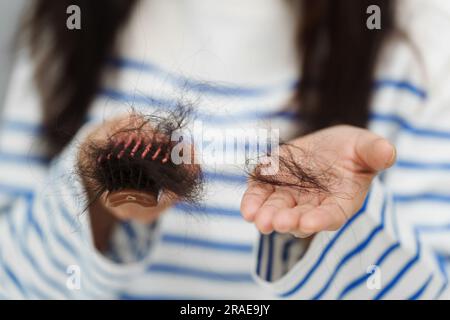 donna da vicino che ha problemi di perdita dei capelli con la sua spazzola per capelli Foto Stock