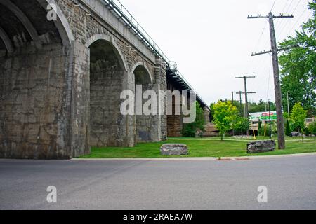 Ponte ferroviario sostenuto da splendidi archi in pietra, che attraversa il fiume Napanee a Springside Park a Napanee, Ontario, Canada -01 Foto Stock