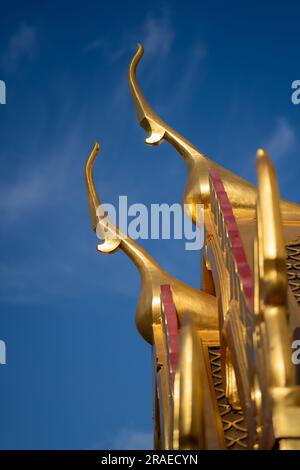 Wat Ratchanatdaram, Bangkok, Thailandia. Decorazione del tempio Chofas finiture decorative dorate del tetto contro il cielo blu. Foto Stock