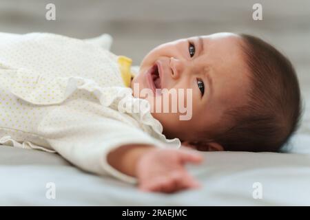 neonato sdraiato e piangendo su un letto Foto Stock