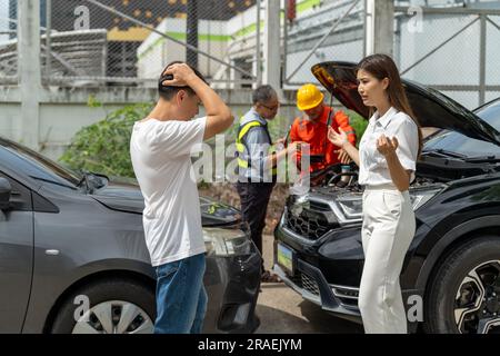 Una giovane donna disordinata che parla in modo angoscioso con un uomo che ha accidentalmente guidato la sua auto e colpito la sua auto mentre l'agente assicurativo e il macchinista stanno discutendo di Foto Stock