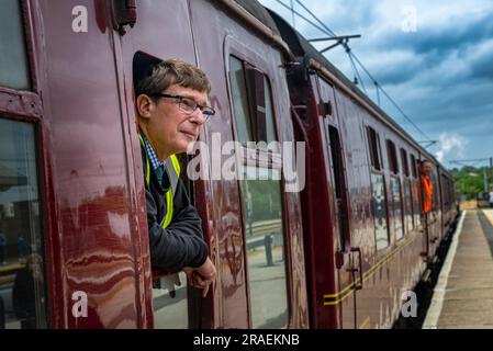 Ritratto della guardia del treno a vapore Flying Scotsman nella stazione di Grantham mentre viaggia da Londra Kings Cross a Edimburgo come parte della celebrazione del centenario Foto Stock