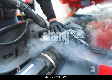 Primo piano del processo di definizione dei dettagli della vettura. Motore di pulizia per lavaggio auto. Pulizia dell'auto a vapore. Lavaggio con motore a vapore. . Foto di alta qualità Foto Stock