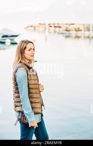 Ritratto di moda all'aperto di una bella giovane donna che posa vicino al lago in un piccolo porto Foto Stock