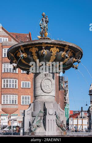 Copenaghen, Danimarca - 15 settembre 2010: Primo piano della fontana della Caritas con statua in bronzo di madre e bambini a Gammeltorv, in centro sotto le nuvole blu Foto Stock