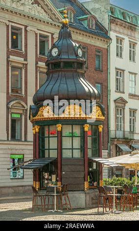 Copenaghen, Danimarca - 15 settembre 2010: Storica cappella con orologio, guglia e decorazioni dorate è il negozio di piatti da asporto per caffè e spuntini di fronte all'histo Foto Stock