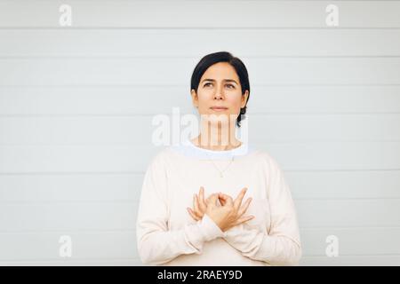 Ritratto della donna che tiene mudra gyan accanto al cuore, posizione della mano da meditazione Kundalini yoga l'amore è amore. Questa meditazione rimuove qualsiasi scommessa di dualità Foto Stock