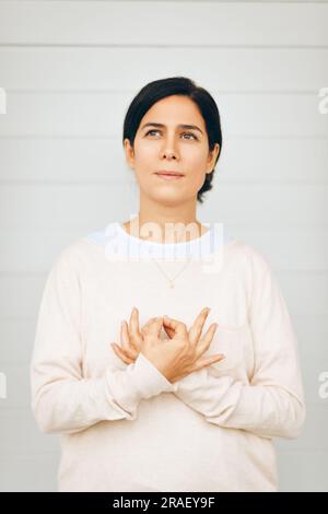 Ritratto della donna che tiene mudra gyan accanto al cuore, posizione della mano da meditazione Kundalini yoga l'amore è amore. Questa meditazione rimuove qualsiasi scommessa di dualità Foto Stock