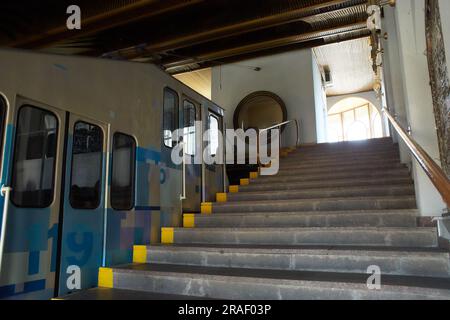 Kiev, Ucraina - 03.08.2023: Una funicolare bianca e blu sorge sui binari lungo il pendio. Funicolare, vista laterale. Stazione Kyiv, Ucraina Foto Stock