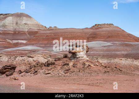 Un caprock di arenaria su un hoodoo di argilla nelle colline bentonite del deserto di Caineville vicino a Hanksville, Utah. Foto Stock