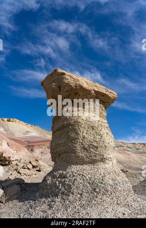 Un caprock di arenaria su un hoodoo di argilla nelle colline bentonite del deserto di Caineville vicino a Hanksville, Utah. Foto Stock