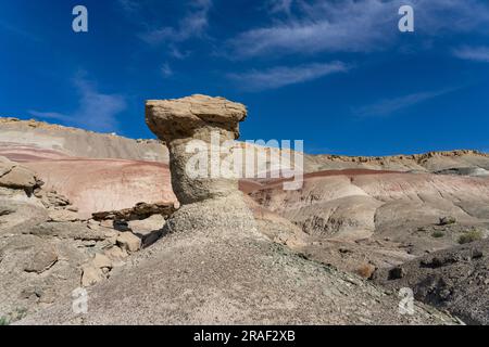 Un caprock di arenaria su un hoodoo di argilla nelle colline bentonite del deserto di Caineville vicino a Hanksville, Utah. Foto Stock