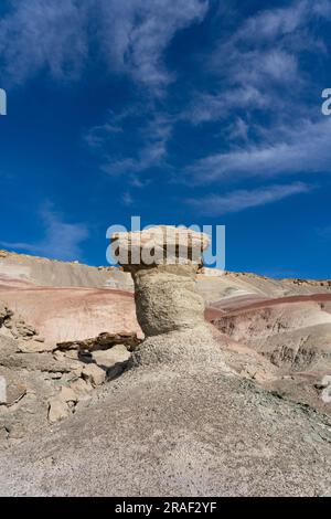 Un caprock di arenaria su un hoodoo di argilla nelle colline bentonite del deserto di Caineville vicino a Hanksville, Utah. Foto Stock