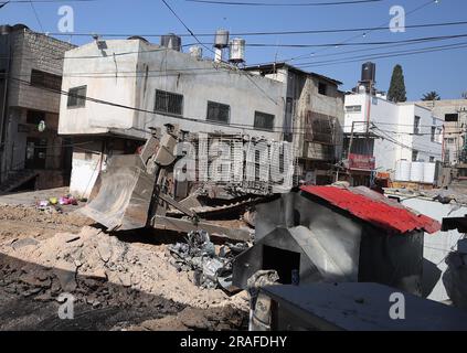 Jenin, territorio palestinese occupato. 3 luglio 2023. Un bulldozer militare israeliano libera una strada durante un'operazione militare israeliana nel campo profughi di Jenin nella Cisgiordania occupata, il 3 luglio 2023. Almeno 9 palestinesi sono stati uccisi e altre due dozzine feriti in un raid dell'esercito israeliano nel campo profughi di Jenin nella Cisgiordania occupata, ha detto lunedì il ministero della salute palestinese. Foto di STR/UPI. Crediti: UPI/Alamy Live News Foto Stock