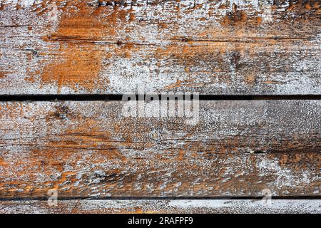 Sfondo, consistenza di vecchie tavole di legno marrone con tracce di vernice bianca sbucciante. Foto Stock