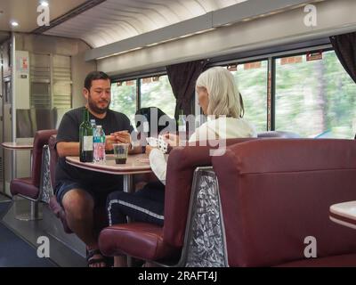 I passeggeri che giocano a un gioco di carte e bevono vino nel bar a bordo del treno Auto Amtrak in viaggio da Sanford, Florida, a Lorton, Virginia, a giugno Foto Stock