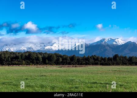 Fotografia dei paddock agricoli e vista sulle montagne durante il viaggio da te Anau a Fiordland a Manapouri, sull'Isola del Sud della nuova Zelanda Foto Stock