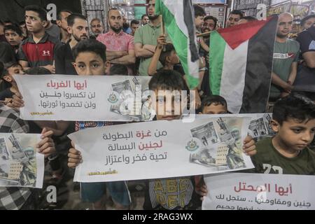 3 luglio 2023, Gaza City, Striscia di Gaza, Palestina: I sostenitori di Hamas sventolano bandiere islamiche verdi mentre alzano le mani e cantano slogan durante una protesta contro un raid militare israeliano nella città di Jenin in Cisgiordania, sulla strada principale del campo profughi di Jebaliya, nella parte settentrionale della Striscia di Gaza, lunedì 3 luglio 2023. Israele ha colpito bersagli in una roccaforte militante nella Cisgiordania occupata con droni all'inizio di lunedì e ha schierato centinaia di truppe nella zona. Funzionari sanitari palestinesi hanno detto che almeno otto palestinesi sono stati uccisi. (Immagine di credito: © Mahmoud Issa/Quds Net News via ZUMA Press Wire) EDITORIALE Foto Stock