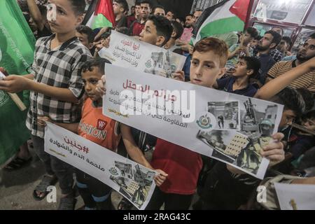 3 luglio 2023, Gaza City, Striscia di Gaza, Palestina: I sostenitori di Hamas sventolano bandiere islamiche verdi mentre alzano le mani e cantano slogan durante una protesta contro un raid militare israeliano nella città di Jenin in Cisgiordania, sulla strada principale del campo profughi di Jebaliya, nella parte settentrionale della Striscia di Gaza, lunedì 3 luglio 2023. Israele ha colpito bersagli in una roccaforte militante nella Cisgiordania occupata con droni all'inizio di lunedì e ha schierato centinaia di truppe nella zona. Funzionari sanitari palestinesi hanno detto che almeno otto palestinesi sono stati uccisi. (Immagine di credito: © Mahmoud Issa/Quds Net News via ZUMA Press Wire) EDITORIALE Foto Stock