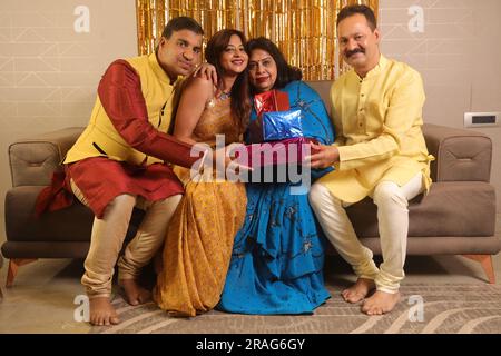 Felice famiglia indiana che si gode la stagione delle feste a Diwali. Regalarsi regali e godersi la vita e le feste con la famiglia Foto Stock