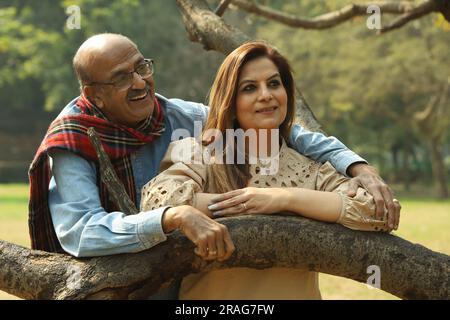 Una coppia indiana anziana si diverte a trascorrere una bella serata romantica nel parco verde. Stanno godendo, sorridendo e trascorrendo momenti di gioia. Foto Stock