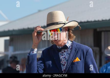Giovane uomo elegante che indossa un cappello di paglia bianco e occhiali da sole riflessivi alle corse Brunette Downs ABC Amateur Bush, un tradizionale evento dell'Outback, Northe Foto Stock