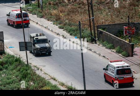 Jenin, Palestina. 3 luglio 2023. Ambulanze viste trasportare vittime dal campo profughi di Jenin agli ospedali della città durante un raid nel campo vicino alla città di Jenin, a nord della Cisgiordania occupata. Un raid dell'esercito israeliano su Jenin, iniziato con diversi attacchi aerei, seguito da un assalto a terra di oltre 100 veicoli corazzati. 9 palestinesi sono stati uccisi e decine sono stati gravemente feriti durante questo raid. Credito: SOPA Images Limited/Alamy Live News Foto Stock