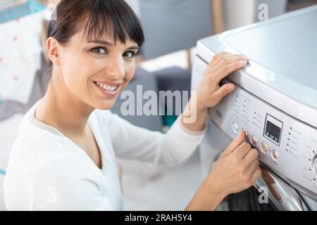 Bella ragazza sorridente nel servizio lavanderia Sala l Foto Stock