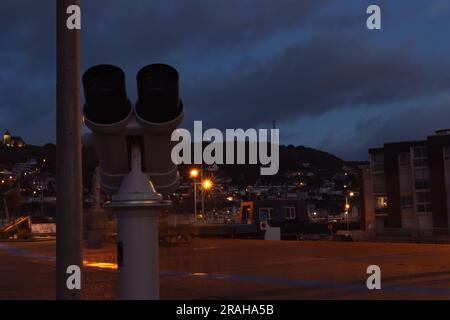 binocolo stazionario da vicino isolato sullo sfondo delle lanterne della città della sera. C'è un posto per un'iscrizione. Foto di alta qualità Foto Stock