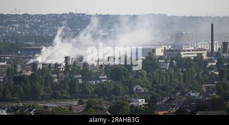 4 luglio 2023, Assia, Francoforte sul meno: Un pennacchio di fumo bianco si propaga nella parte orientale della città mentre i vigili del fuoco lavorano per spegnere un incendio in un impianto di riciclaggio. Un magazzino è andato in fiamme martedì sera. Secondo i vigili del fuoco, tuttavia, non c'era alcun pericolo per la popolazione. Foto: Arne Dedert/dpa Foto Stock