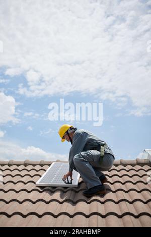 Appaltatore solare che installa pannelli sul tetto, concetto di energia rinnovabile Foto Stock