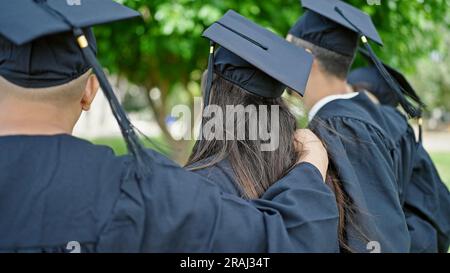 Gruppo di studenti laureati abbracciandosi a ritroso nel campus universitario Foto Stock