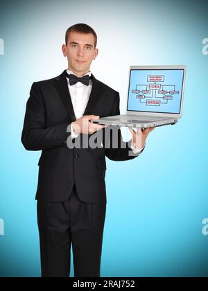 uomo d'affari in stile smoking con un notebook con un concetto di business sullo schermo Foto Stock