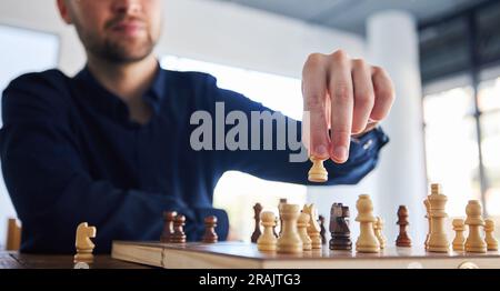 Scacchi, uomo che muove una pedina e gioco di strategia, risoluzione dei problemi o persona che gioca a scacchiera in competizione. Pianificazione, scelta e mano su cavaliere o. Foto Stock