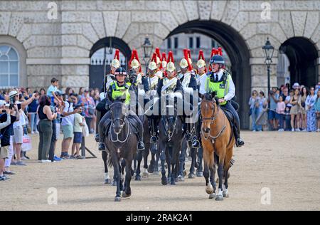 Londra, Regno Unito. Membro della Household Cavalry (Blues and Royals) scortato dalla polizia a cavallo dalla Horse Guards Parade dopo il cambio giornaliero del .. Foto Stock