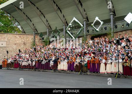 Dobele, Lettonia - 27 maggio 2023. Molti cantanti corali popolari misti in costumi nazionali si esibiscono su un palco durante la XXVII canzone lettone nazionale e XVII Foto Stock