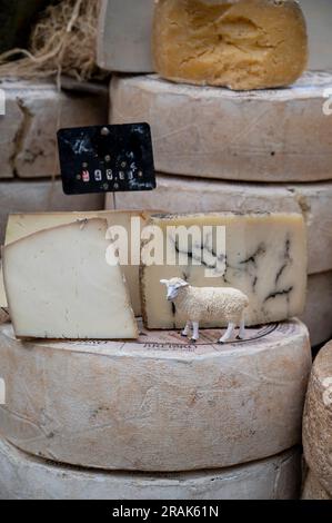 Una bancarella di formaggio in un mercato nella Valle della Loira di Chinon, Francia, con formaggio accumulato per la vendita. Foto Stock