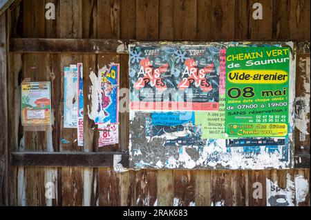 Manifesti usurati e sbucciati su una bacheca di legno nella Valle della Loira di Montsoreau, Francia, Foto Stock