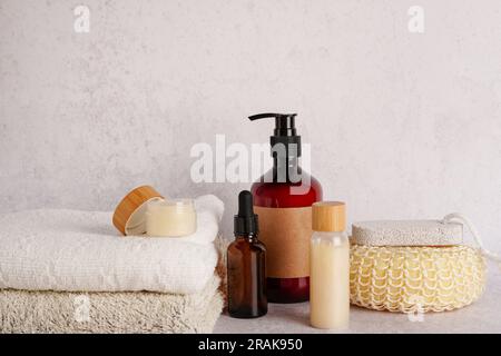 Cosmetica SPA branding mock-up, prodotti per la cura del corpo, salviette e asciugamani su fondo di cemento chiaro, cosmetici ecologici naturali Foto Stock